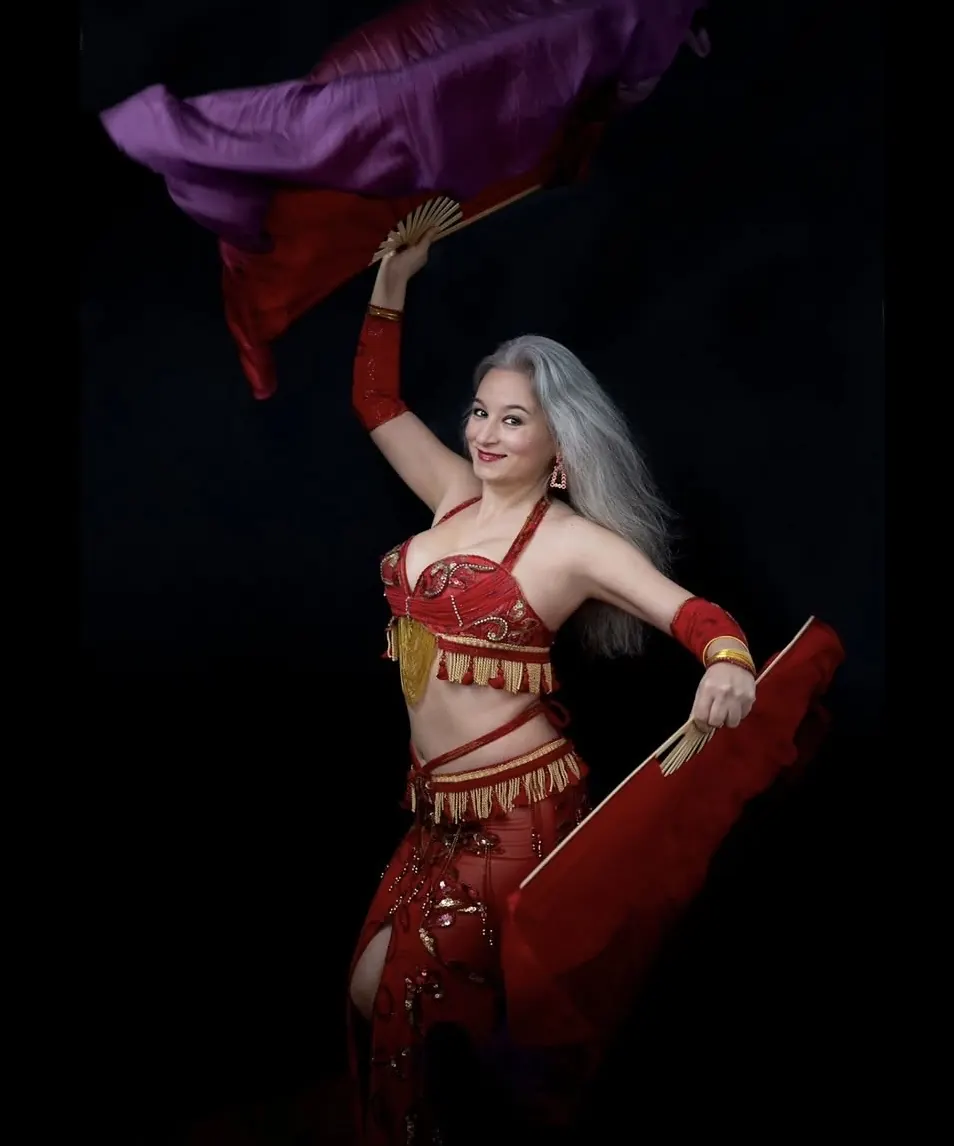 Alexandra performing bellydance with red silk fans
